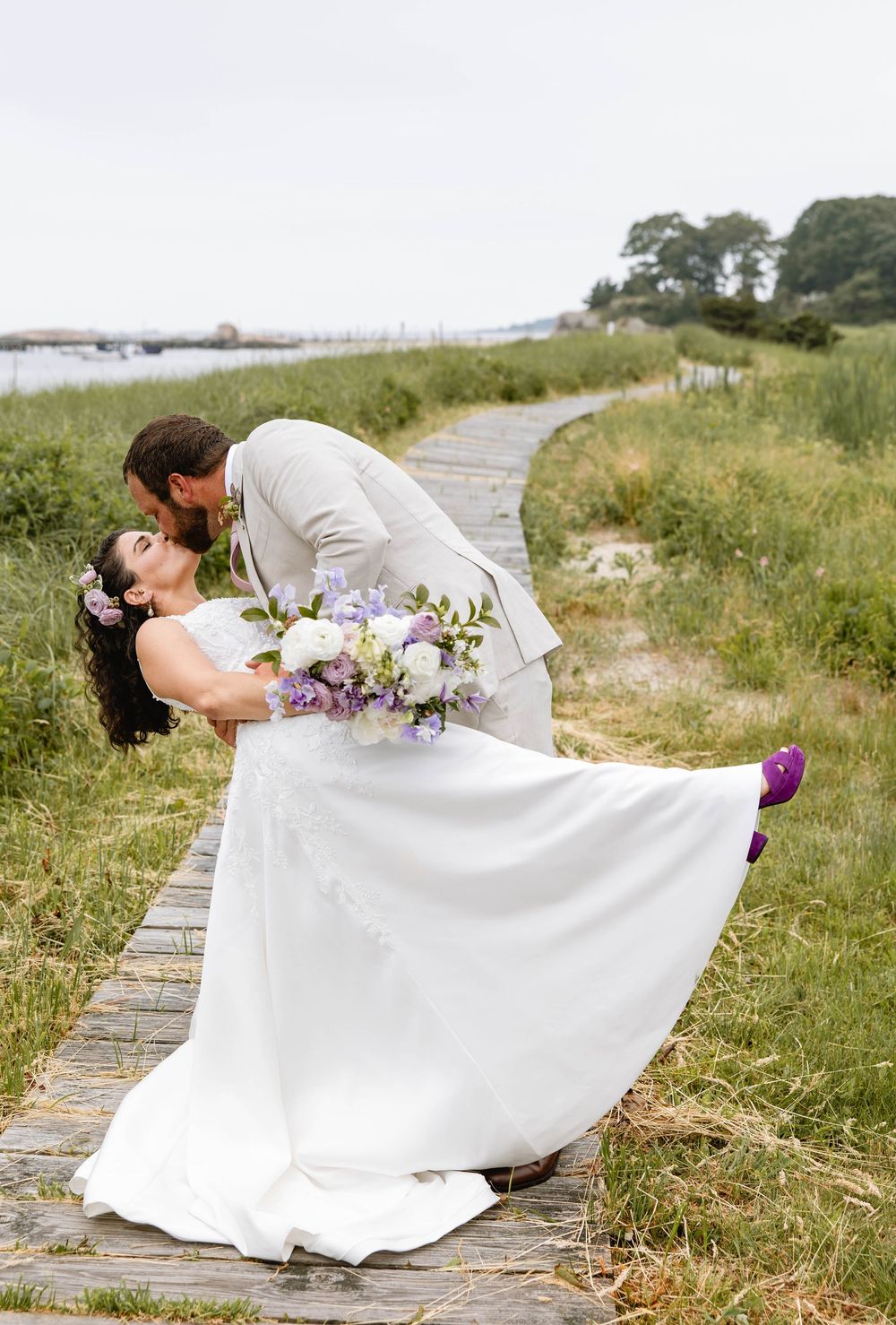 A dramatic wedding photo series showing a romantic dip pose on a coastal pathway. Nonquitt beach. New England Wedding.