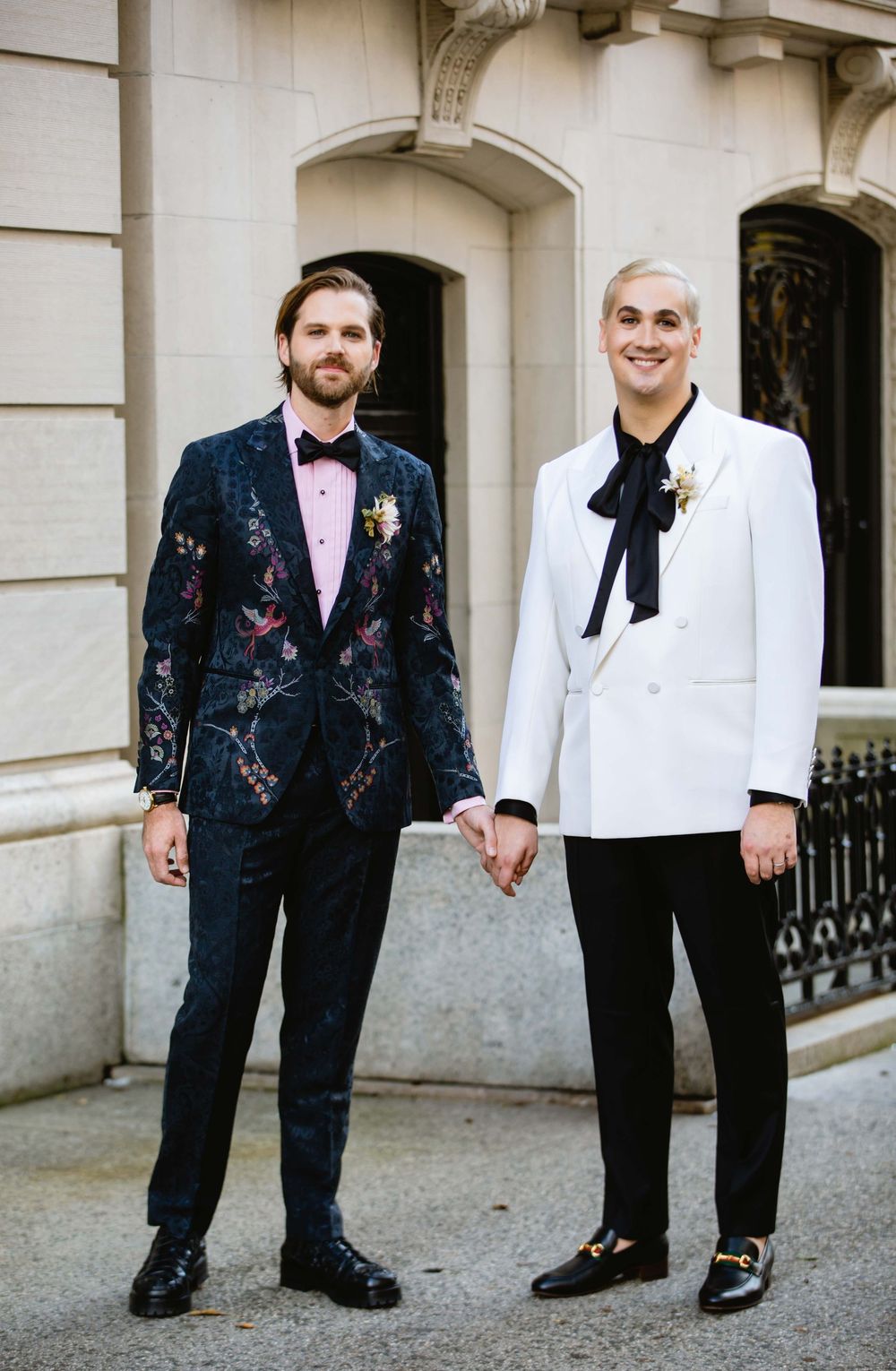 Two pairs of formal shoes shown from waist down with floral and classic tuxedo details.