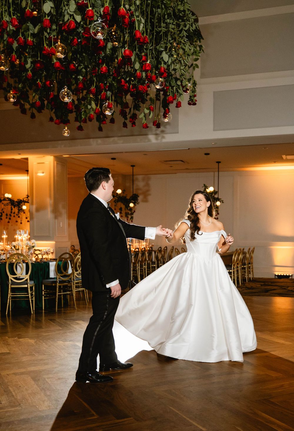 Couple dancing in formal attire under red floral ceiling decorations in ballroom. Cescaphe wedding. The Lucy wedding.