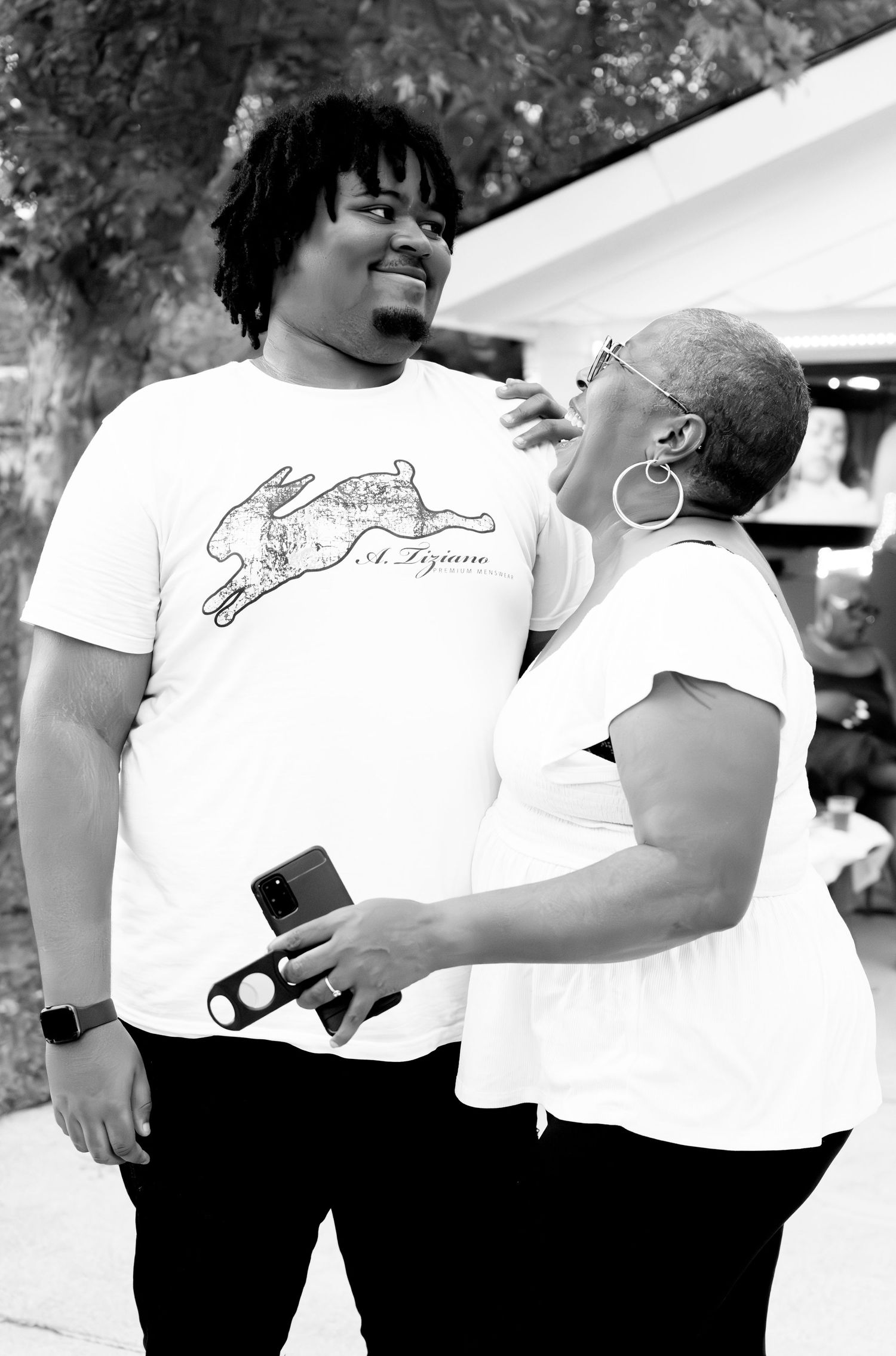 A candid black and white photo showing two people sharing a warm embrace.
