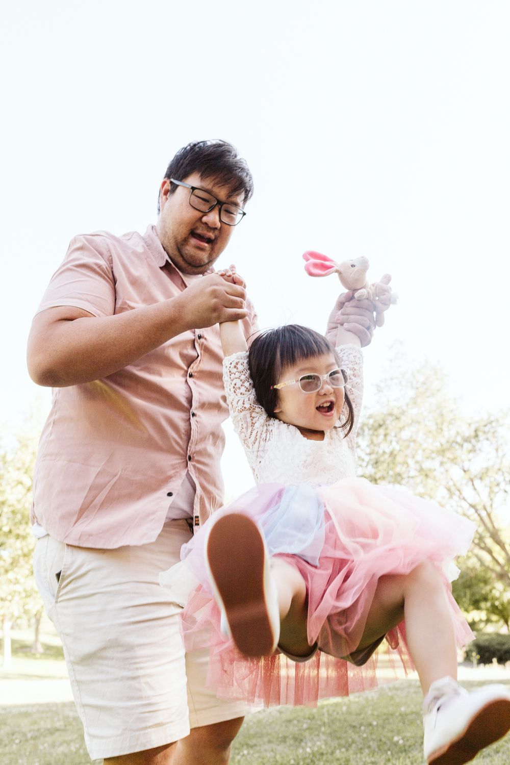 Playful moment captured as a child is lifted up high during outdoor playtime.