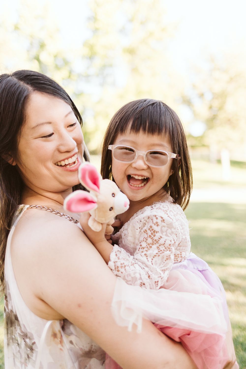 Joyful moment shared while holding a small stuffed bunny toy outdoors.