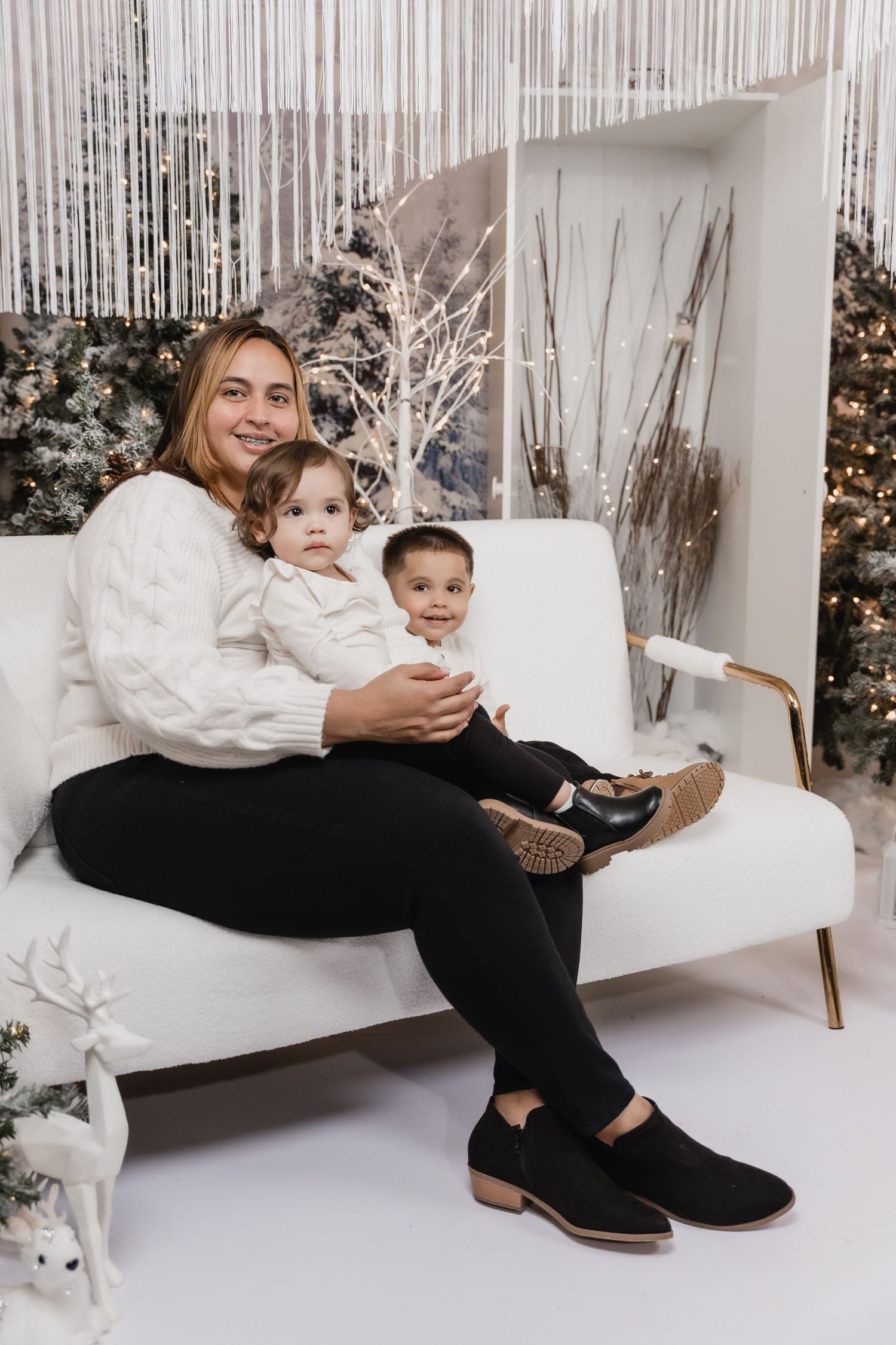 Winter portrait against silver tinsel backdrop with white festive decorations.