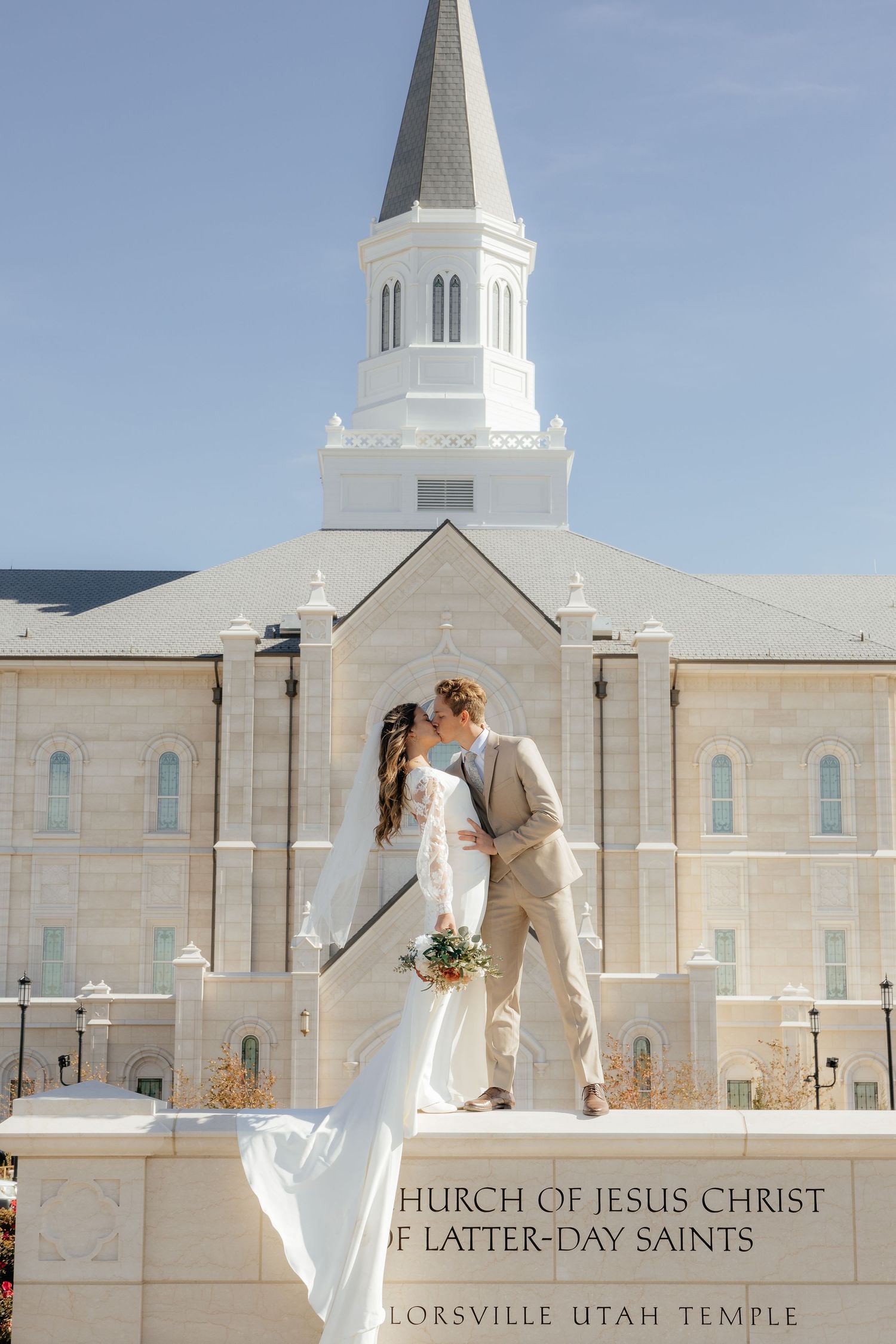 Couple kissing at Taylorsville Utah LDS Temple on their wedding day.