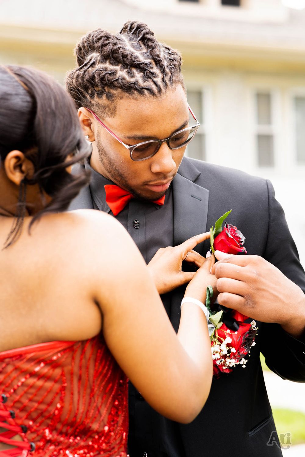 Close-up of corsage being pinned on formal attire before special event.