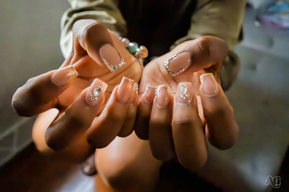 Close-up of hands showing off delicate white nail art designs.