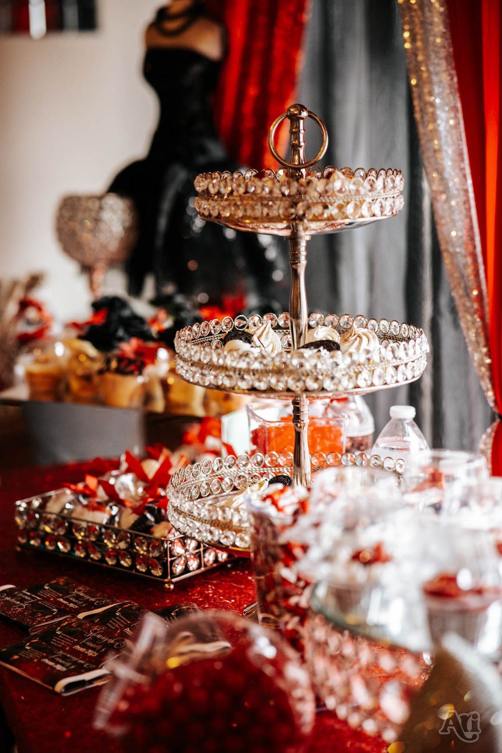 Ornate crystal tiered dessert stand on elegant red and silver party table display.