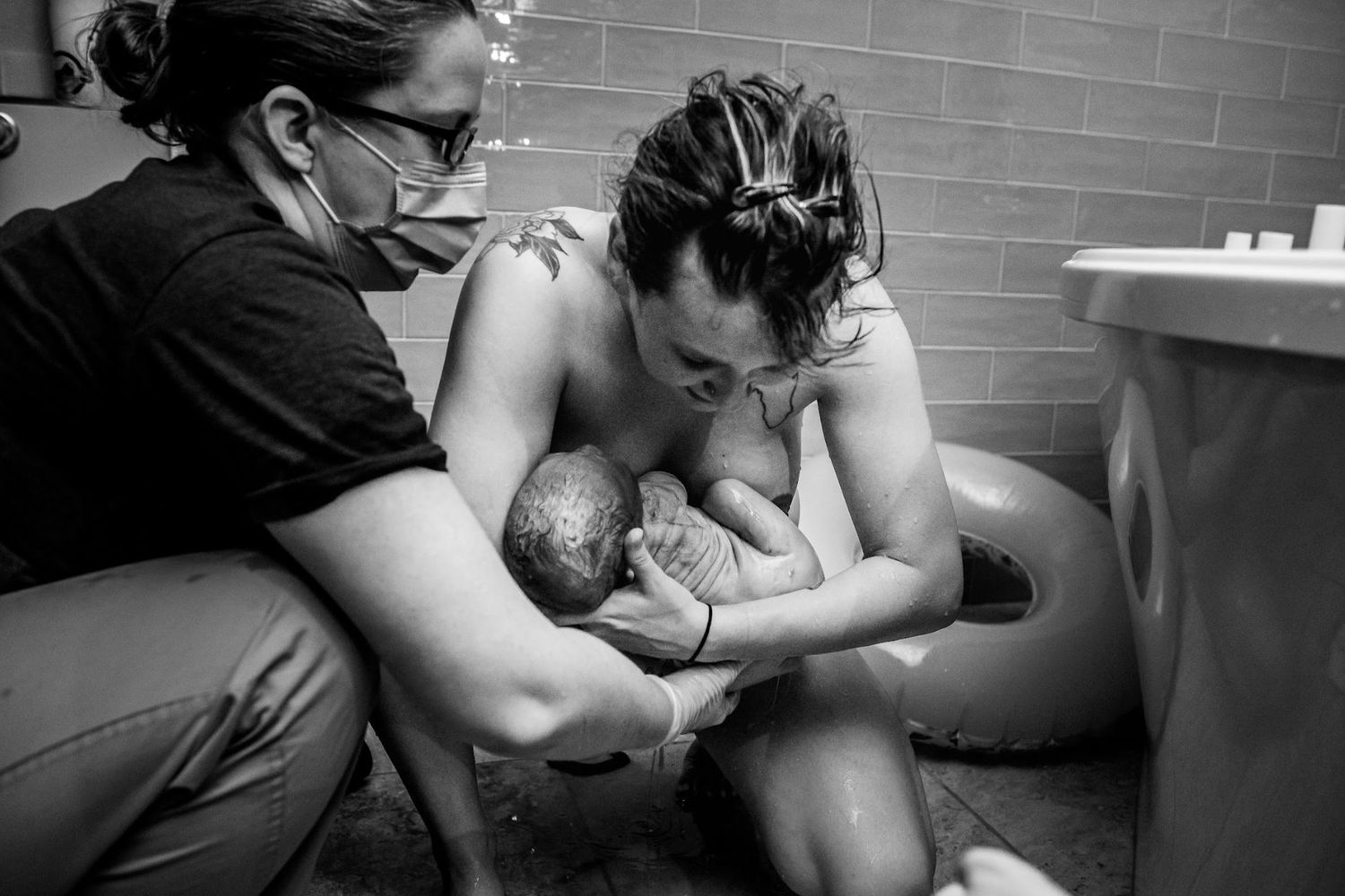 Black and white image of a tender moment of the birth of a baby