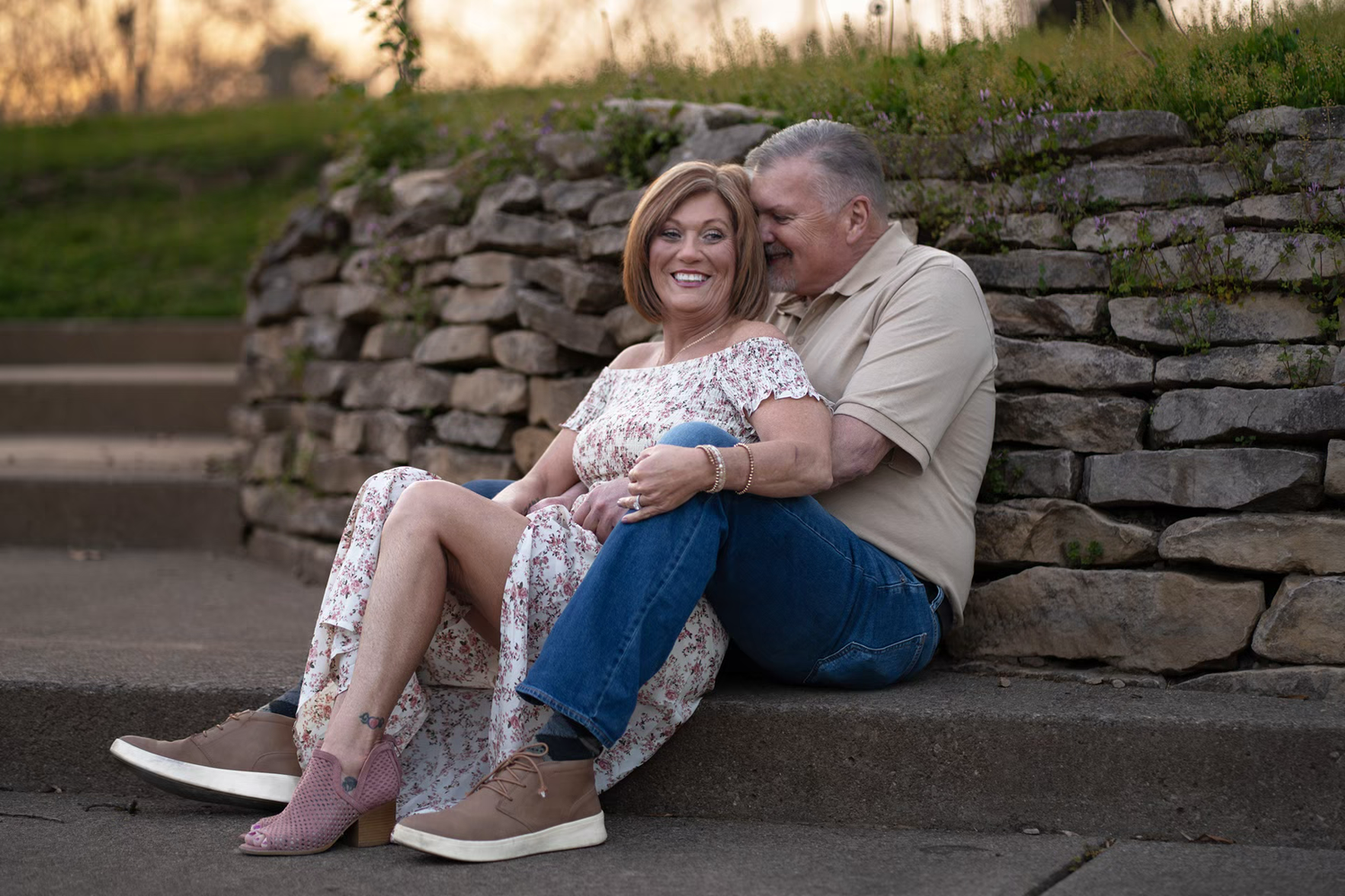 Couple sitting together on stone steps outdoors, at Franklin Park Conservatory for an elegant Engagement Photos