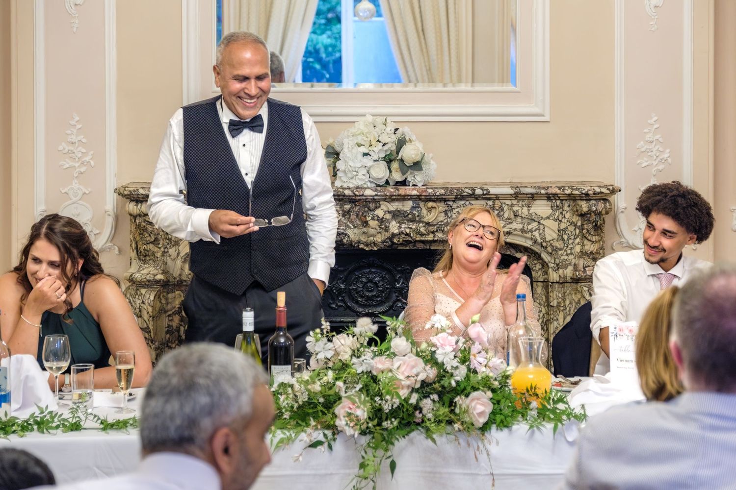 A bride and groom standing together and smiling on their wedding day.