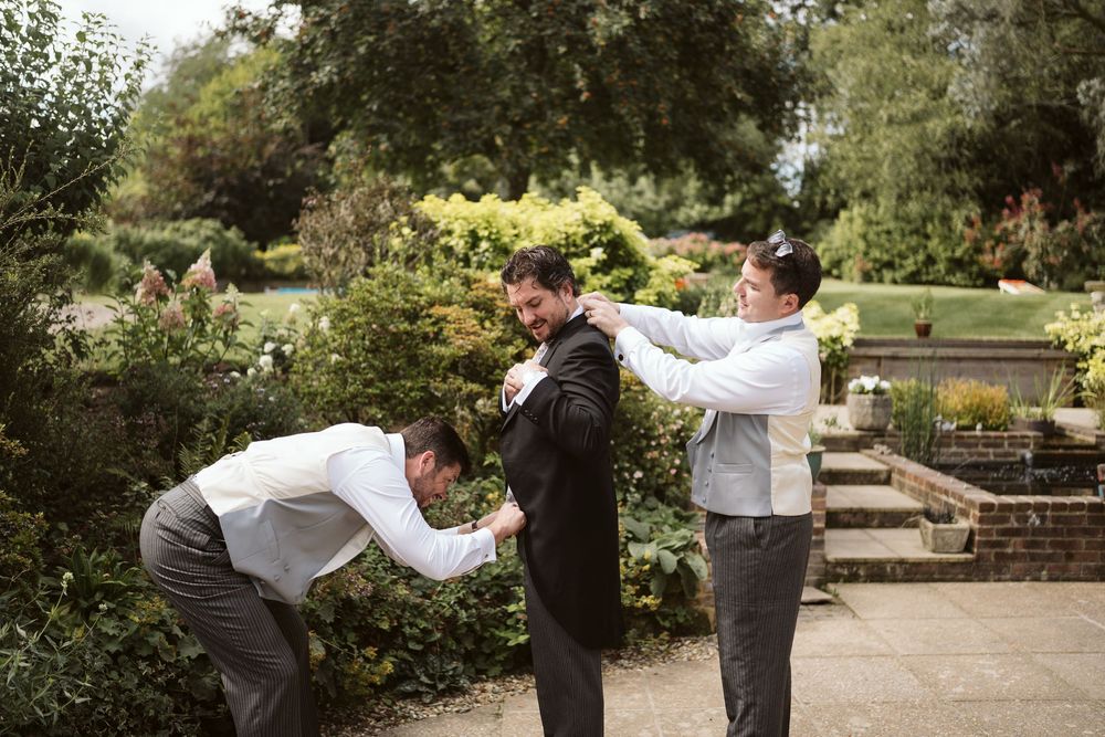 Groomsmen greeting each other outside wedding venue in Surrey