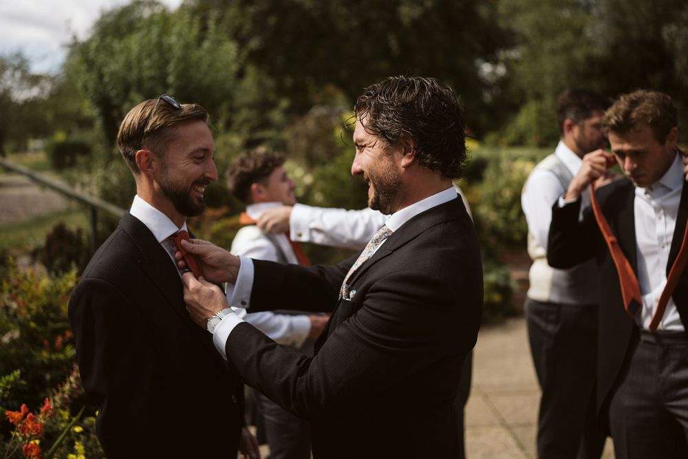 Groom greeting groomsman with a hug on the morning of a Surrey wedding