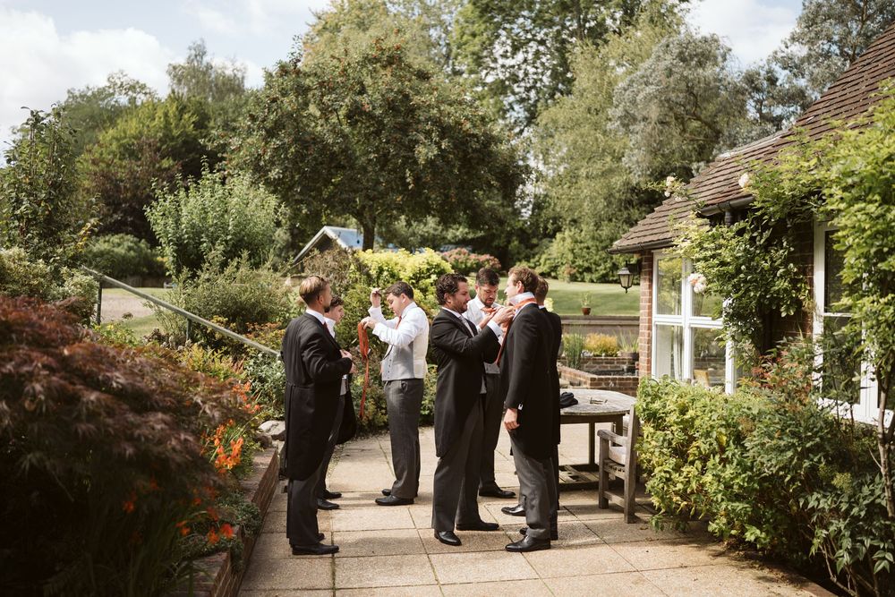 Groomsmen gathering in a garden on a summer wedding day in Surrey