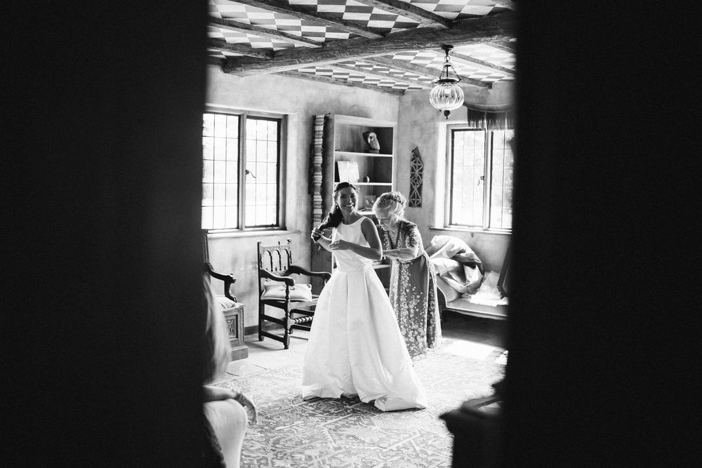 Bride in white wedding gown getting ready, black and white wedding photography Surrey