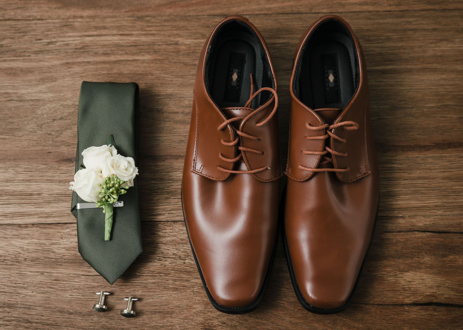 Groom wedding details including brown shoes green tie and boutonniere at Briar Barn Inn Massachusetts