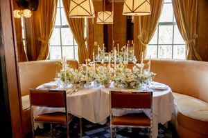 Elegant sweetheart table with white floral centerpiece, tall candles at the Golden Swan Restaurant in New York City.