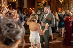 Bride and groom dancing joyfully with guests at a rustic wedding reception celebration at Mountain Creek in Vernon, NJ.