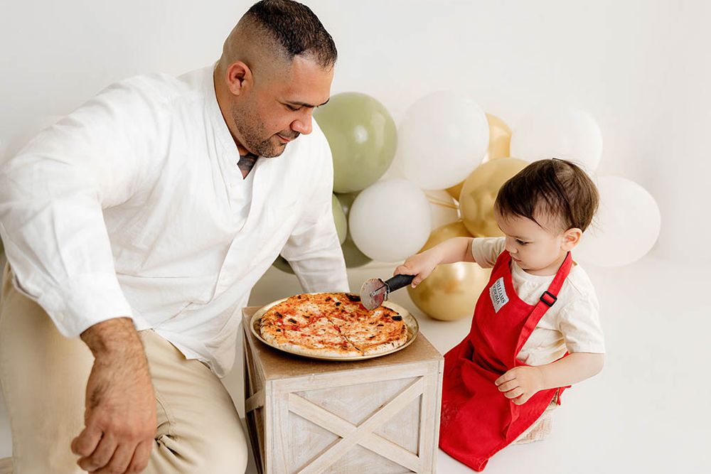 Dad and toddler share a pizza together in fun birthday photography session in Menifee California.