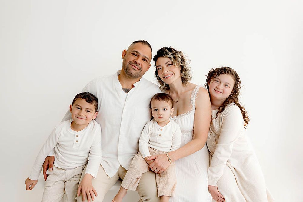 Menifee family & child photographer portrait of family posing together against a white background in a professional studio.