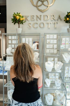 Kendra Scott jewelry store interior with elegant display cases and gold logo signage.