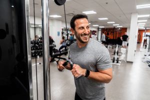 Person working out with exercise equipment in modern fitness center.