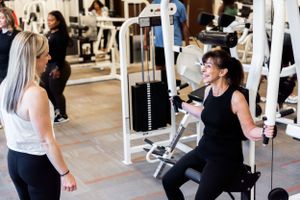 Two people interacting during workout session at fitness facility.