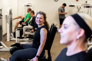 People exercising in modern fitness center with equipment.