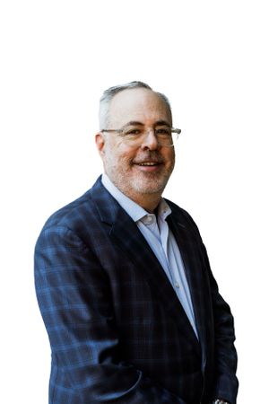 Professional business portrait of man wearing checkered blazer against white background.