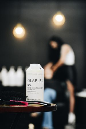 Olaplex hair product bottle displayed on table with salon lighting.