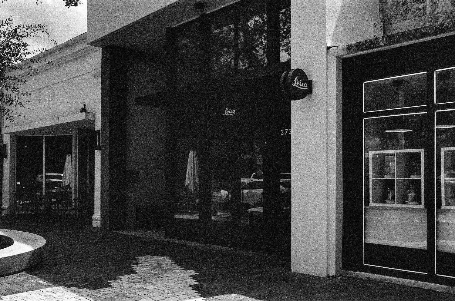 Black and white storefront view with awnings and windows.