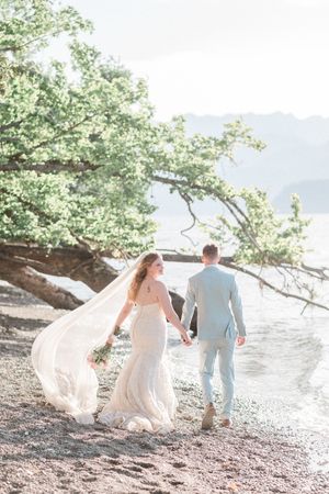 Bride and groom walking along Scenic Beach at Scenic Beach state Park in Washington.