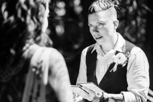 A black and white photo of brides crying while reading vows to one another