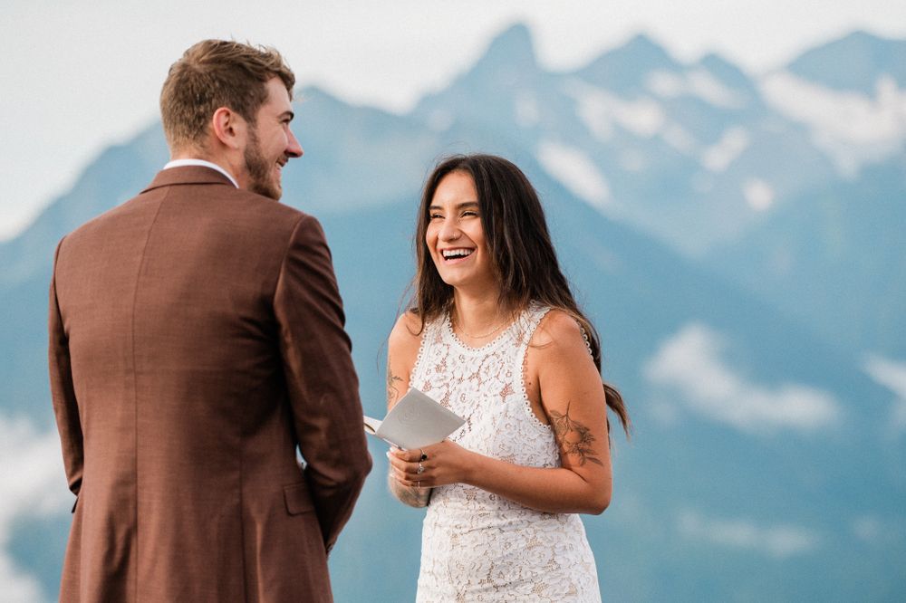 A couple shares a romantic moment against a backdrop of snow-capped mountain peaks in Mt. Rainier National Park on their wedding day.