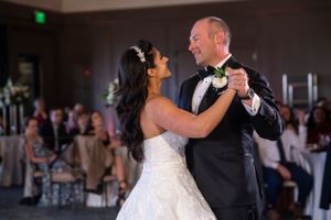A couple shares their first dance at their wedding reception in a banquet hall with guests watching at The Club at Arrowcreek