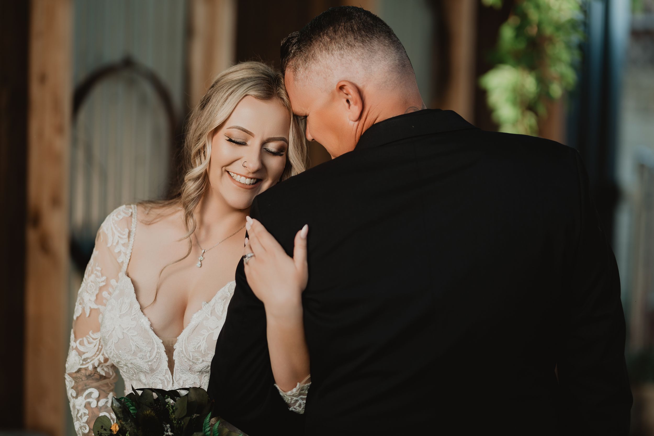 Intimate moment between couple during wedding photoshoot in elegant formal attire.