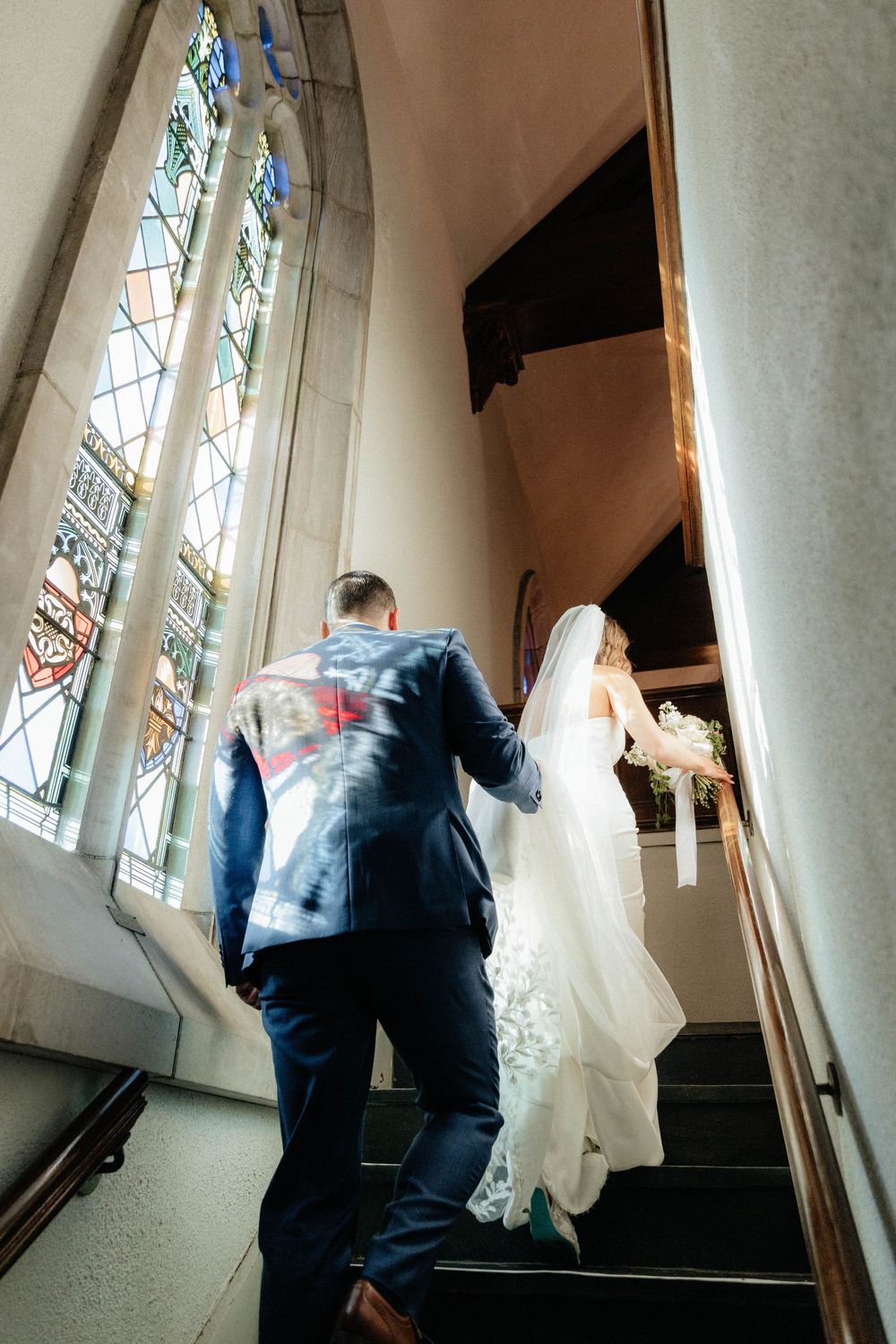 A sequence of images showing someone walking up a stairwell with stained glass windows along the wall.