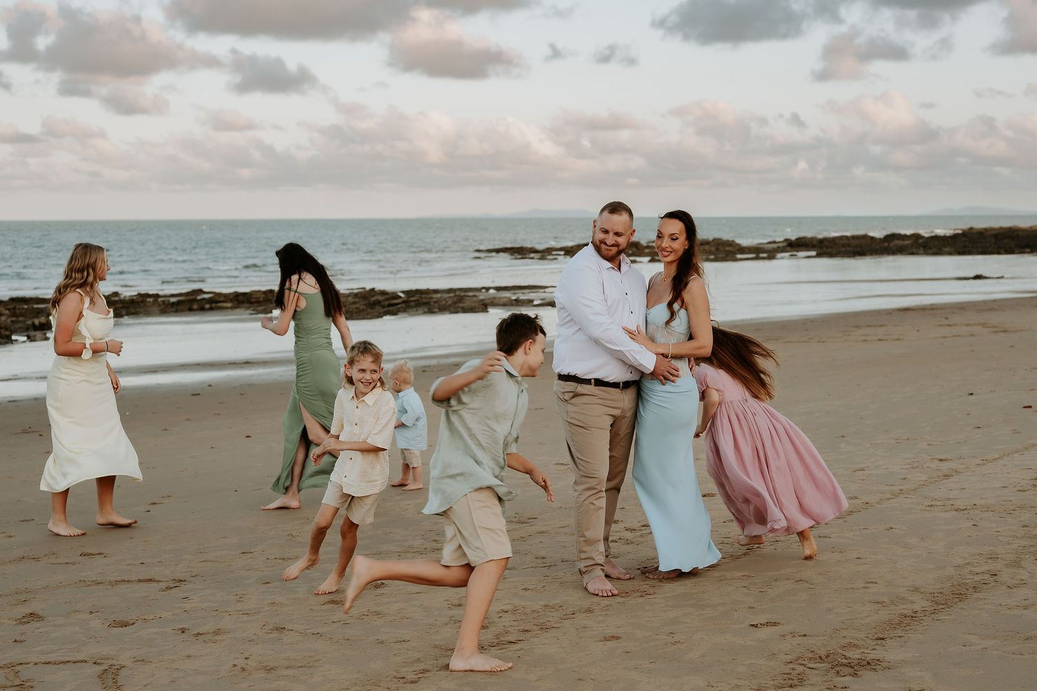 People playing and posing on tannum sands beach during golden hour.