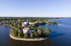 Aerial view of waterfront properties and coastline with lush greenery.