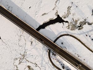 A snowy mountain ridge stretches across the frame with dramatic shadows and textures.