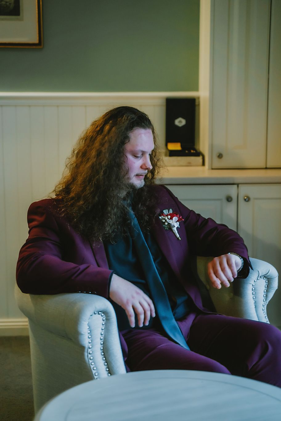 A person in a purple blazer sits on a white couch in a series of progressive reclining positions.