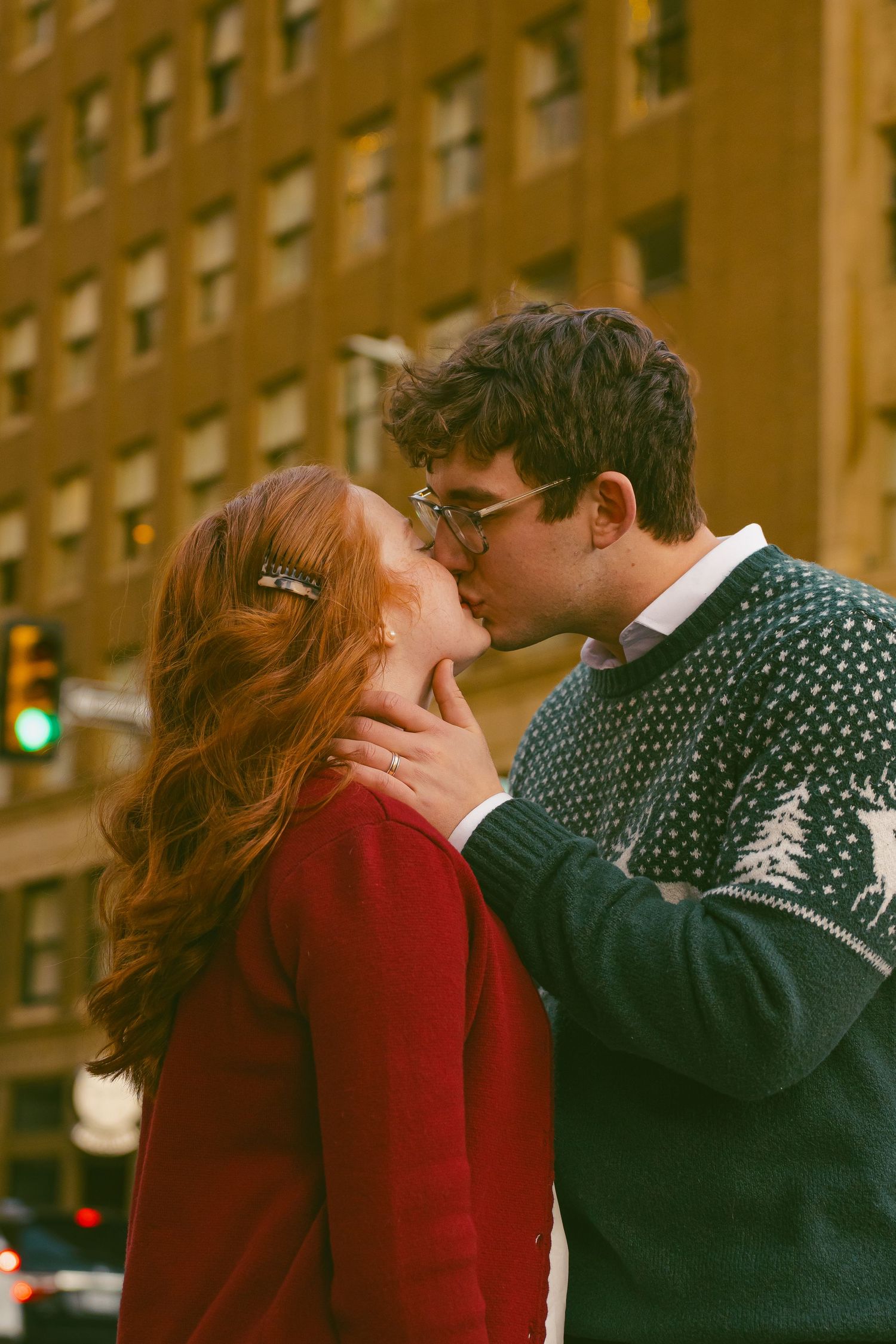 Couple in winter sweaters sharing romantic moment in urban setting.