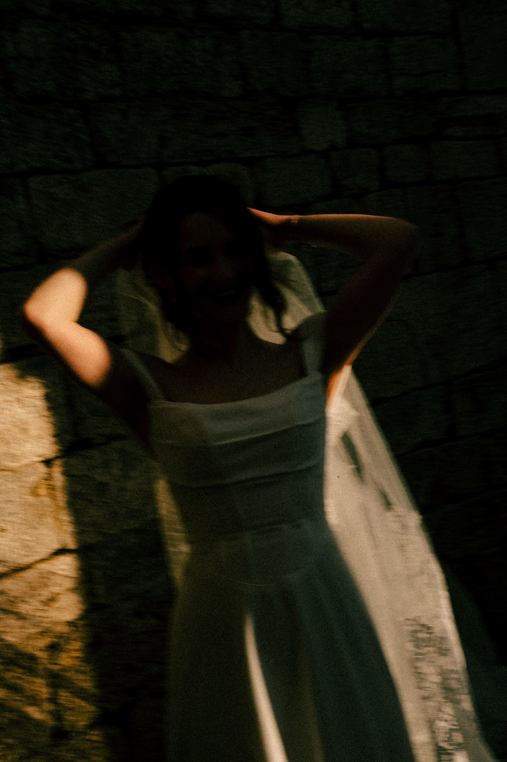 Dark silhouettes of figures in motion against a shadowy background create an atmospheric dance performance scene.