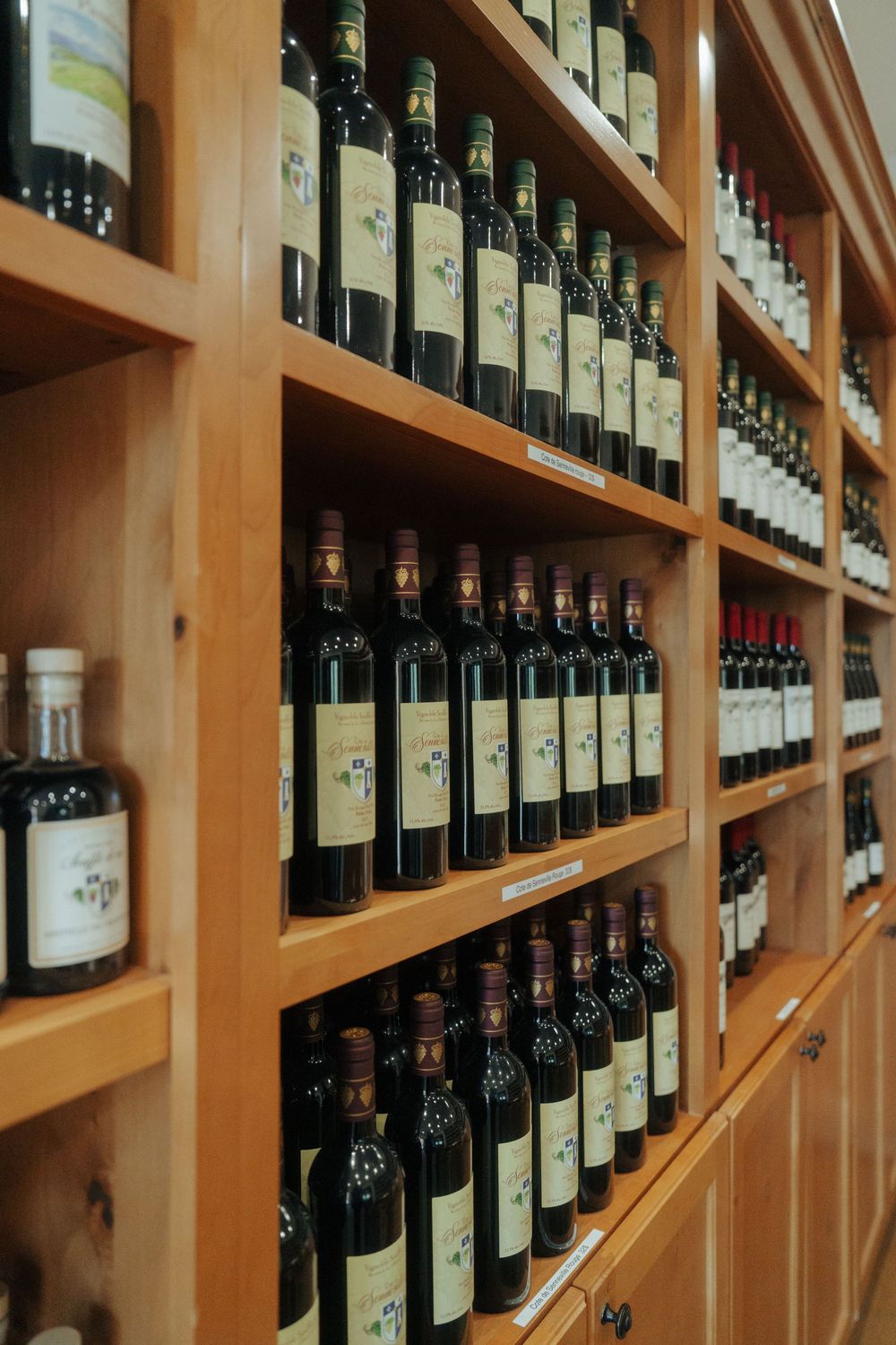 Wooden wine rack filled with bottles displayed in organized rows.