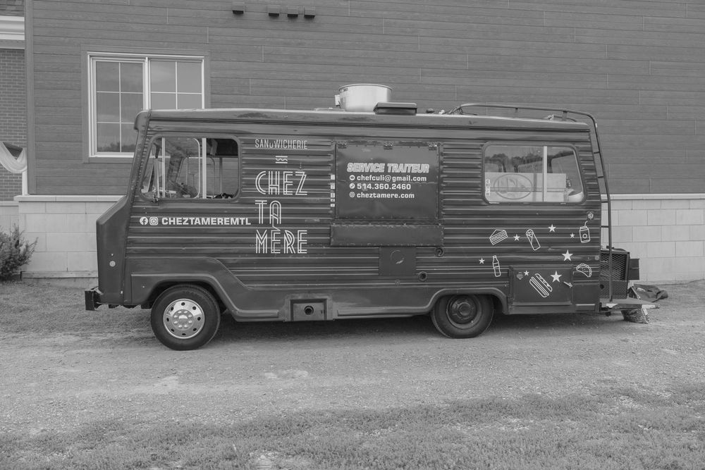Vintage Volkswagen Type 2 van customized with commercial branding and signage parked on a street.