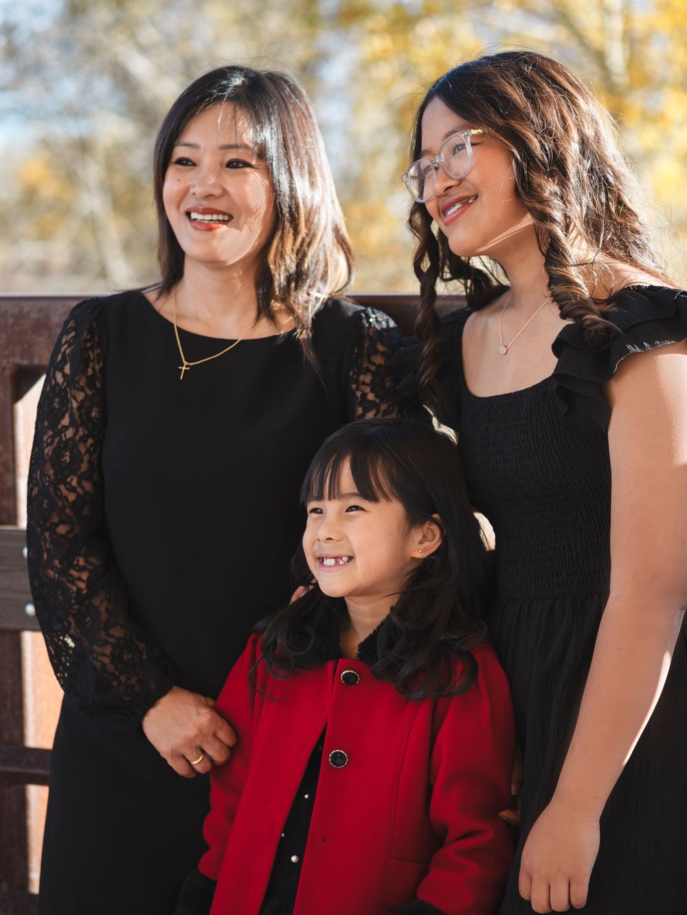 A series of candid outdoor photos showing joyful moments between people wearing black and red outfits in autumn lighting.