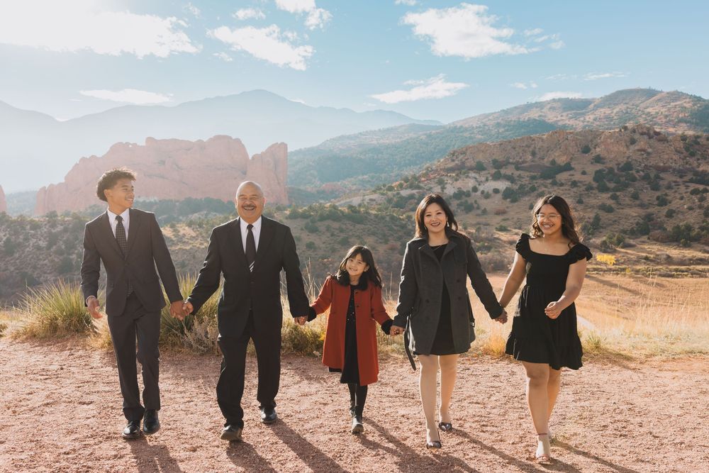Group walking together through a desert landscape with mountains in the background at sunset.