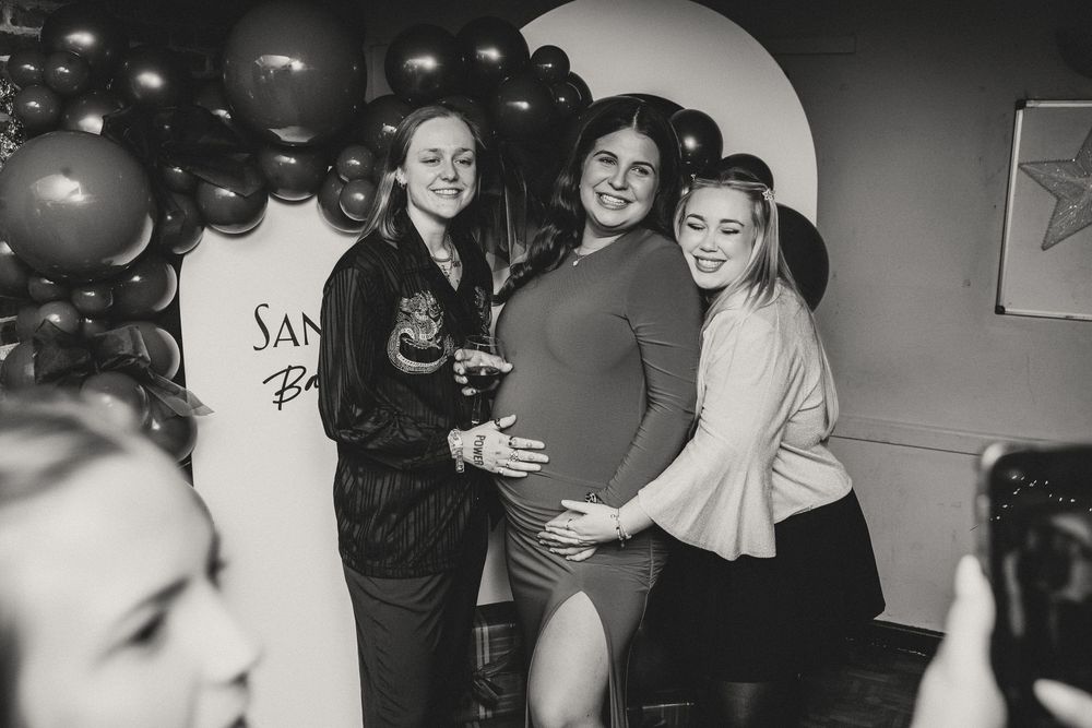 Black and white photos showing people dancing and celebrating at what appears to be a baby shower party.