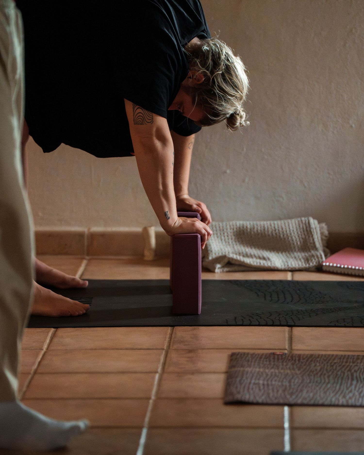 Feet walking across a wooden floor with gray rugs or mats laid out in a row.