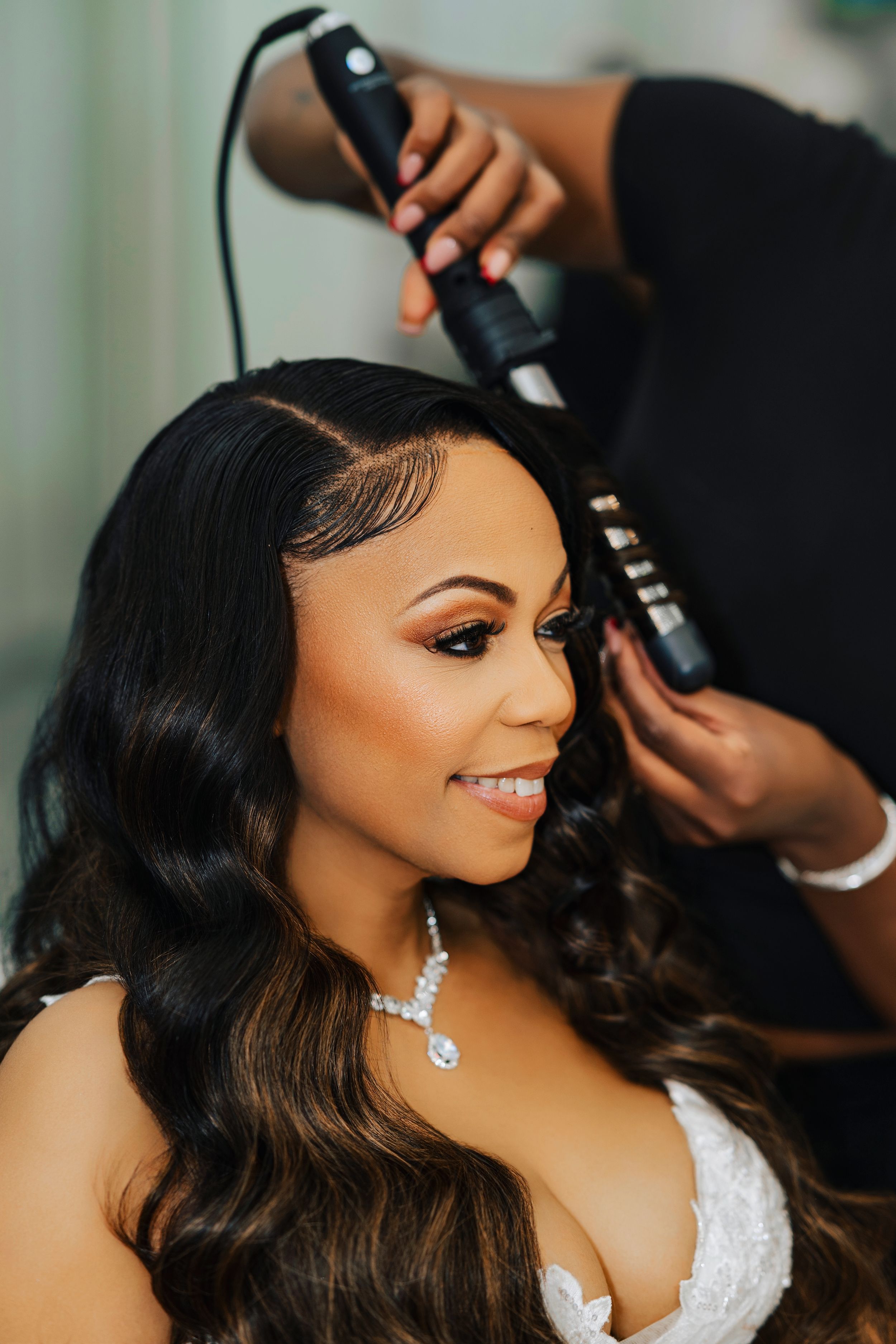 Professional makeup artist applies finishing touches to a bride's glamorous wedding day look.