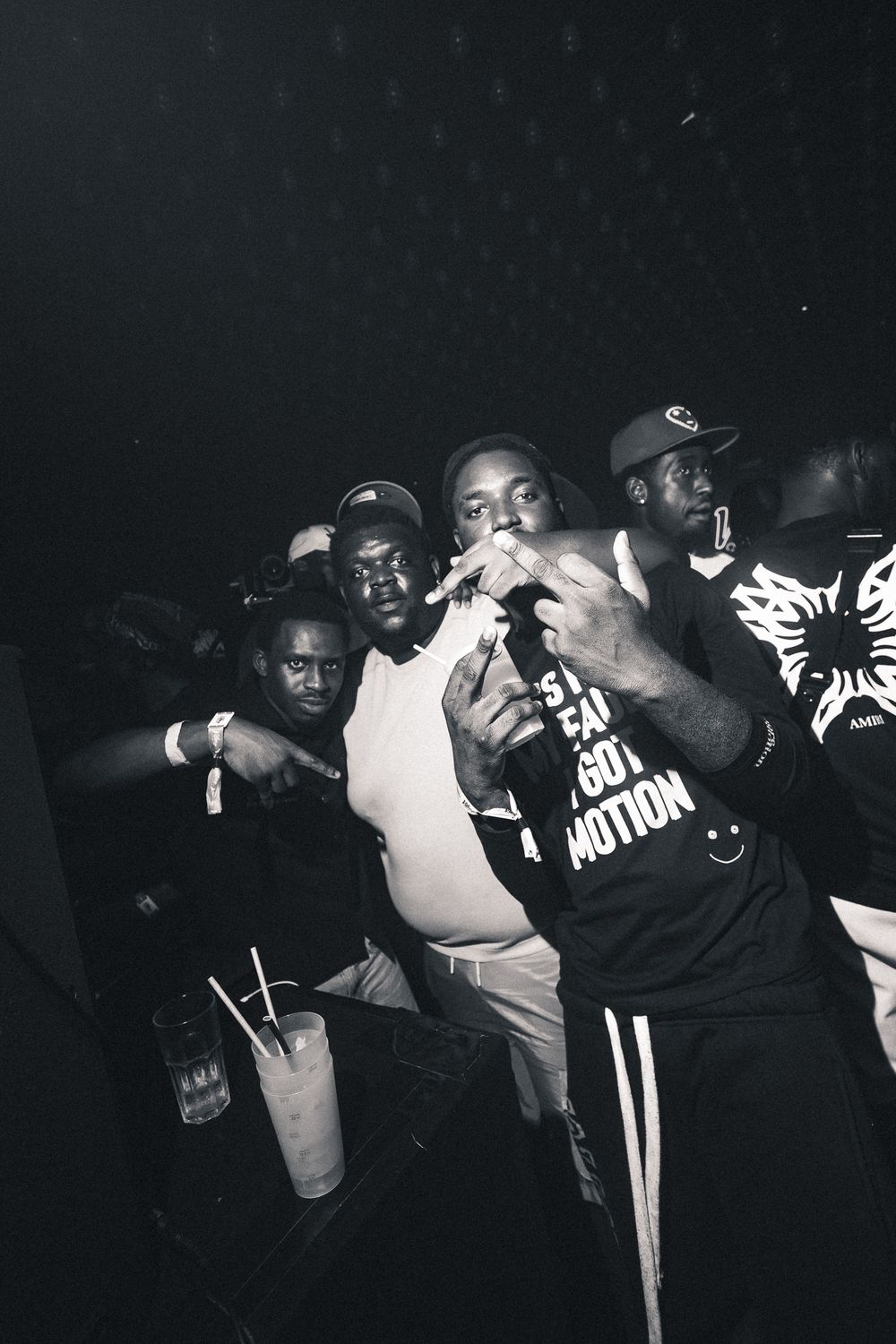 People moving and dancing in sequence at a dimly lit club party.